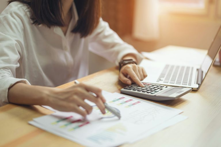 Businesswoman in office and use computer and calculator to perform financial accounting